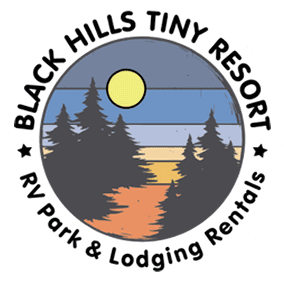 Circular logo for Black Hills Tiny Resort with a sunset, trees, and the text "RV Park & Lodging Rentals.