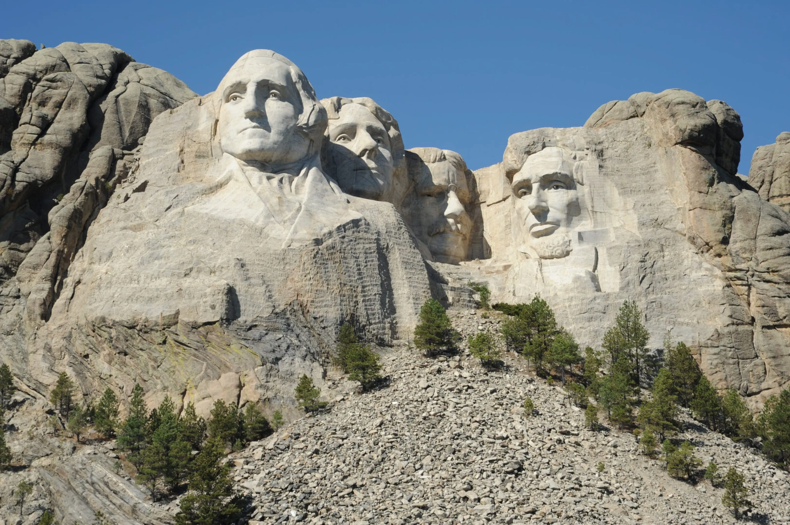 A mountain with four faces carved into it.
