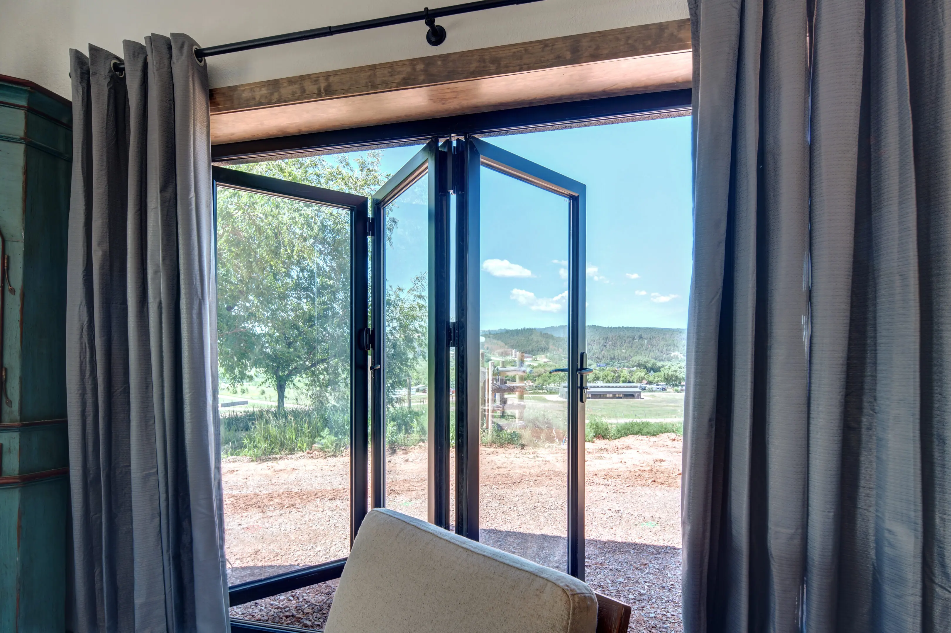 A room with two large glass doors open to the outside.