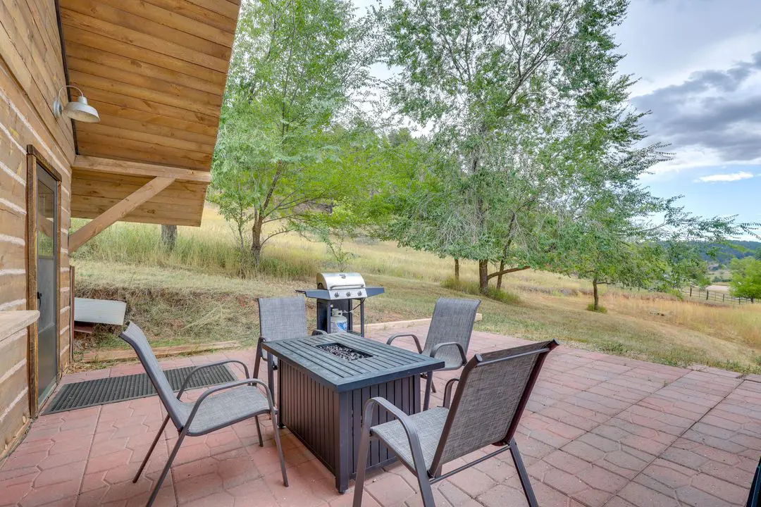 A patio with chairs and table outside of the house.