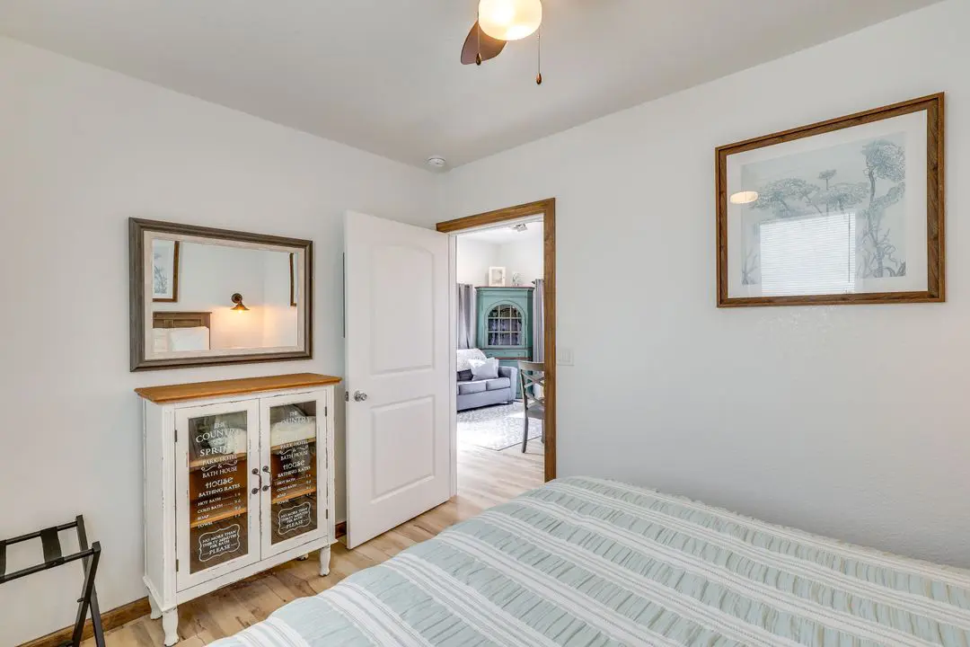 A bedroom with a bed, dresser and mirror.