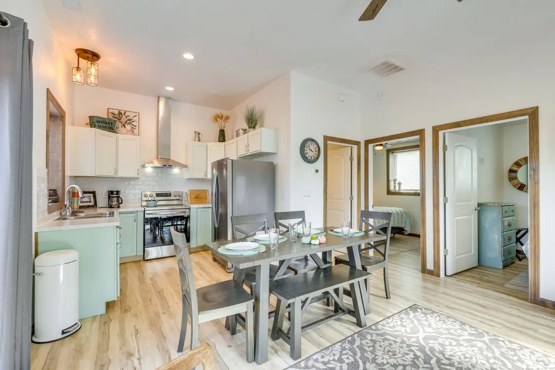 A kitchen with a dining table and chairs.